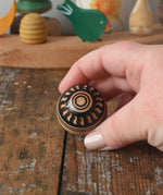 Mader orient turn-over spinning top shown in an adult's hand.
