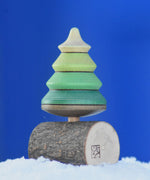 A Mader Tree Spinning Top On Branch placed on a snow covered surface outdoors in the Babipur garden. 