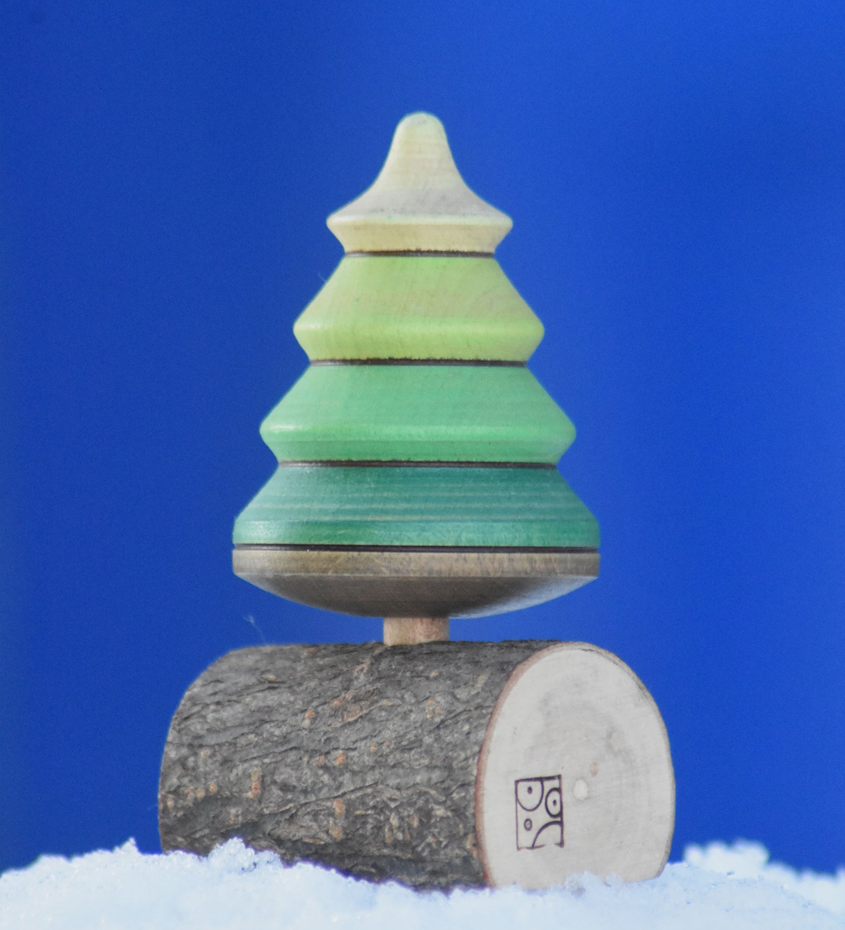 A Mader Tree Spinning Top On Branch placed on a snow covered surface outdoors in the Babipur garden. 