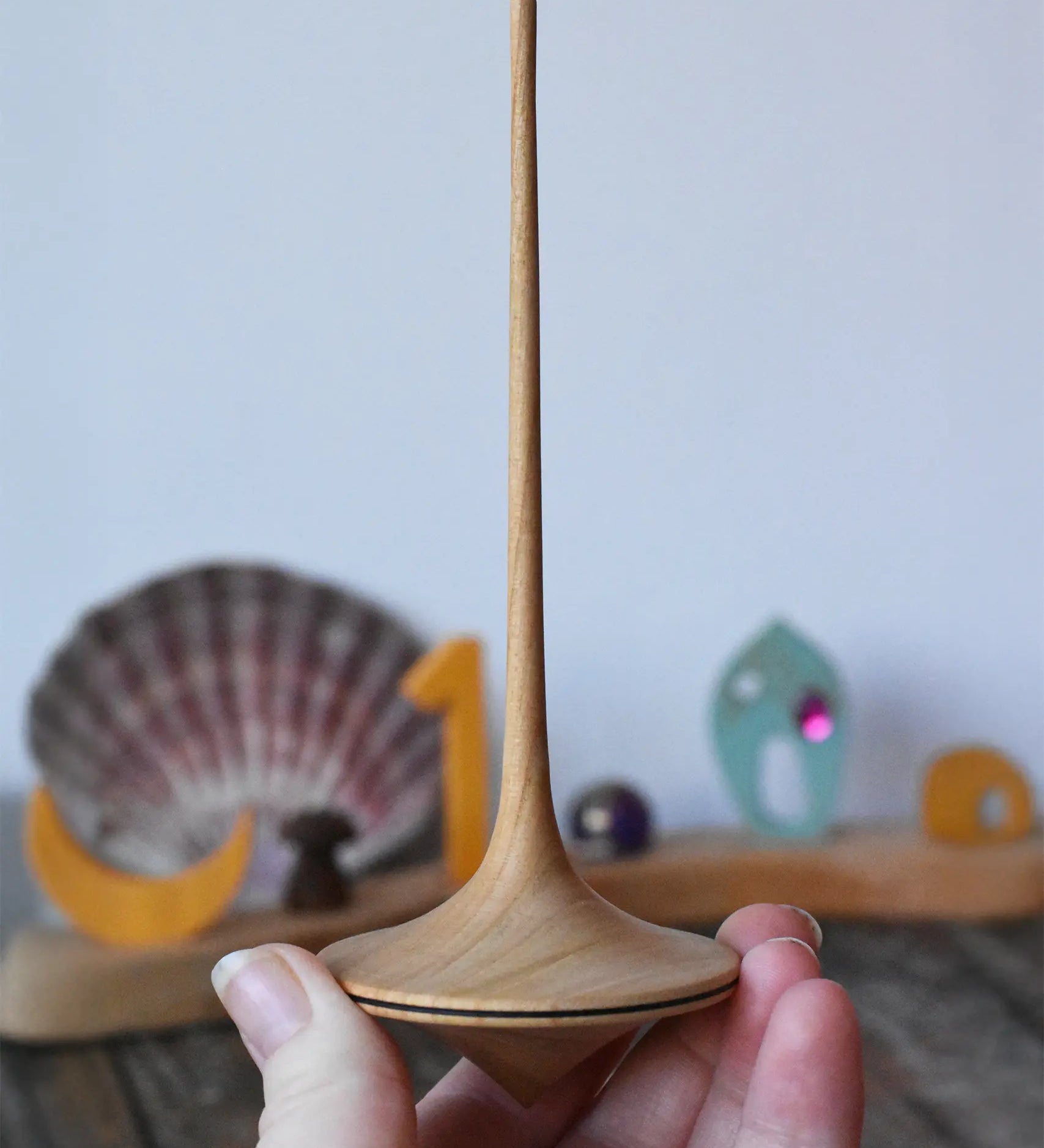 Mader trumpo spinning top 55mm in an adult's hand.