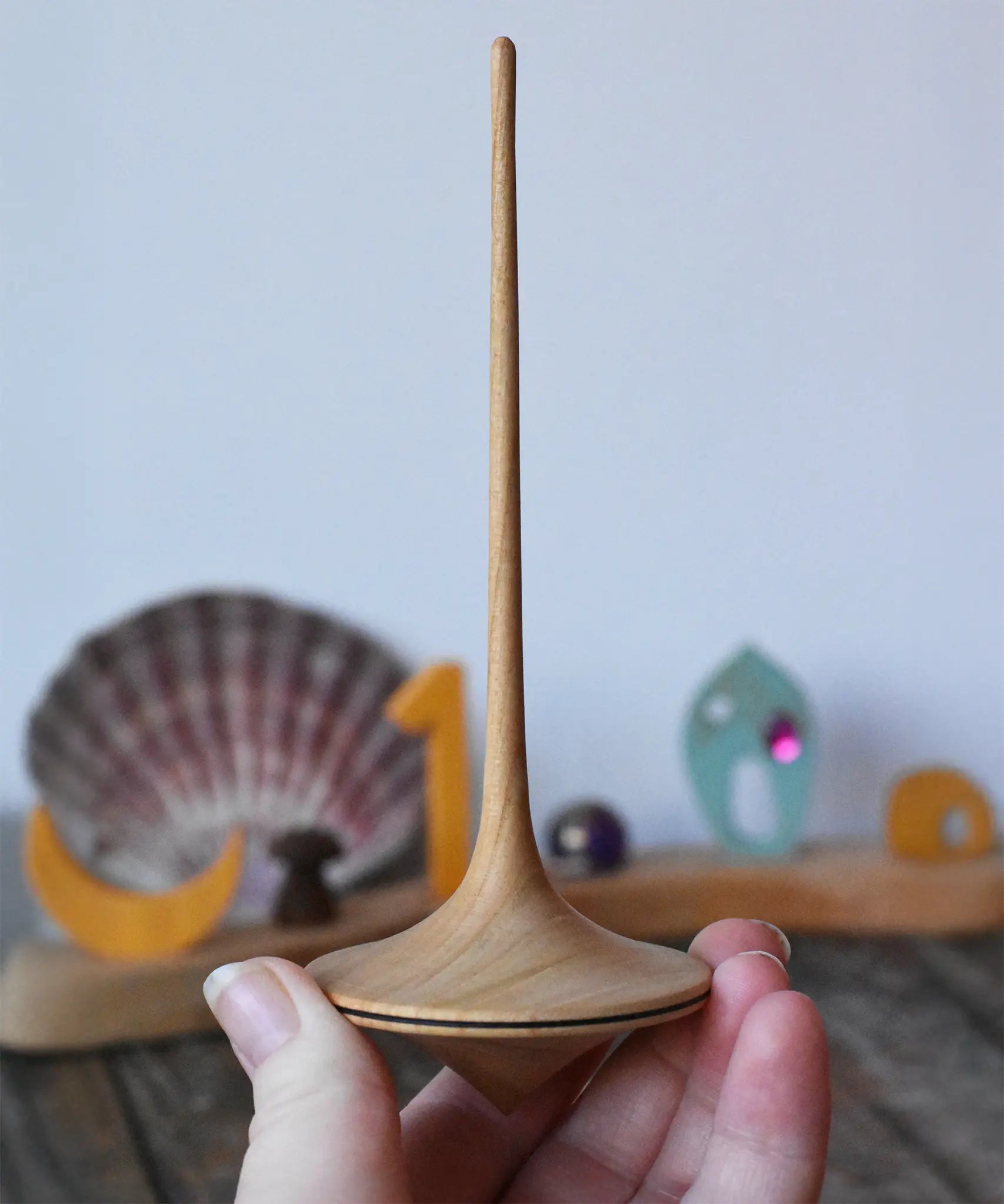 Mader trumpo spinning top 55mm in an adult's hand.