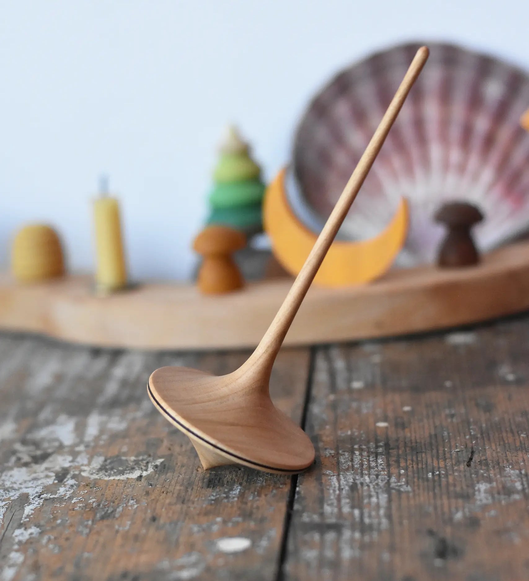 Mader trumpo spinning tops 55mm placed on a wooden surface in the Babipur playroom.