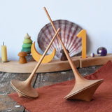 Mader trumpo spinning tops 75mm and 55mm placed on a wooden surface in the Babipur playroom.