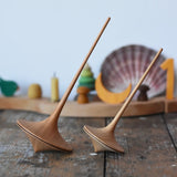Mader trumpo spinning tops 75mm and 55mm placed on a wooden surface in the Babipur playroom.