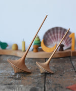 Mader trumpo spinning tops 75mm and 55mm placed on a wooden surface in the Babipur playroom.