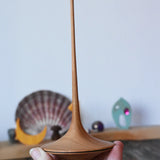 Mader trumpo spinning tops 75mm in an adult's hand.
