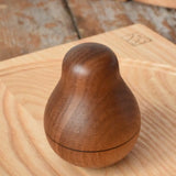 Mader Kreiselmanufaktur walnut roly-poly pear wooden toy placed on an ash spinning plate in the Babipur playroom. 