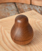 Mader Kreiselmanufaktur walnut roly-poly pear wooden toy placed on an ash spinning plate in the Babipur playroom. 
