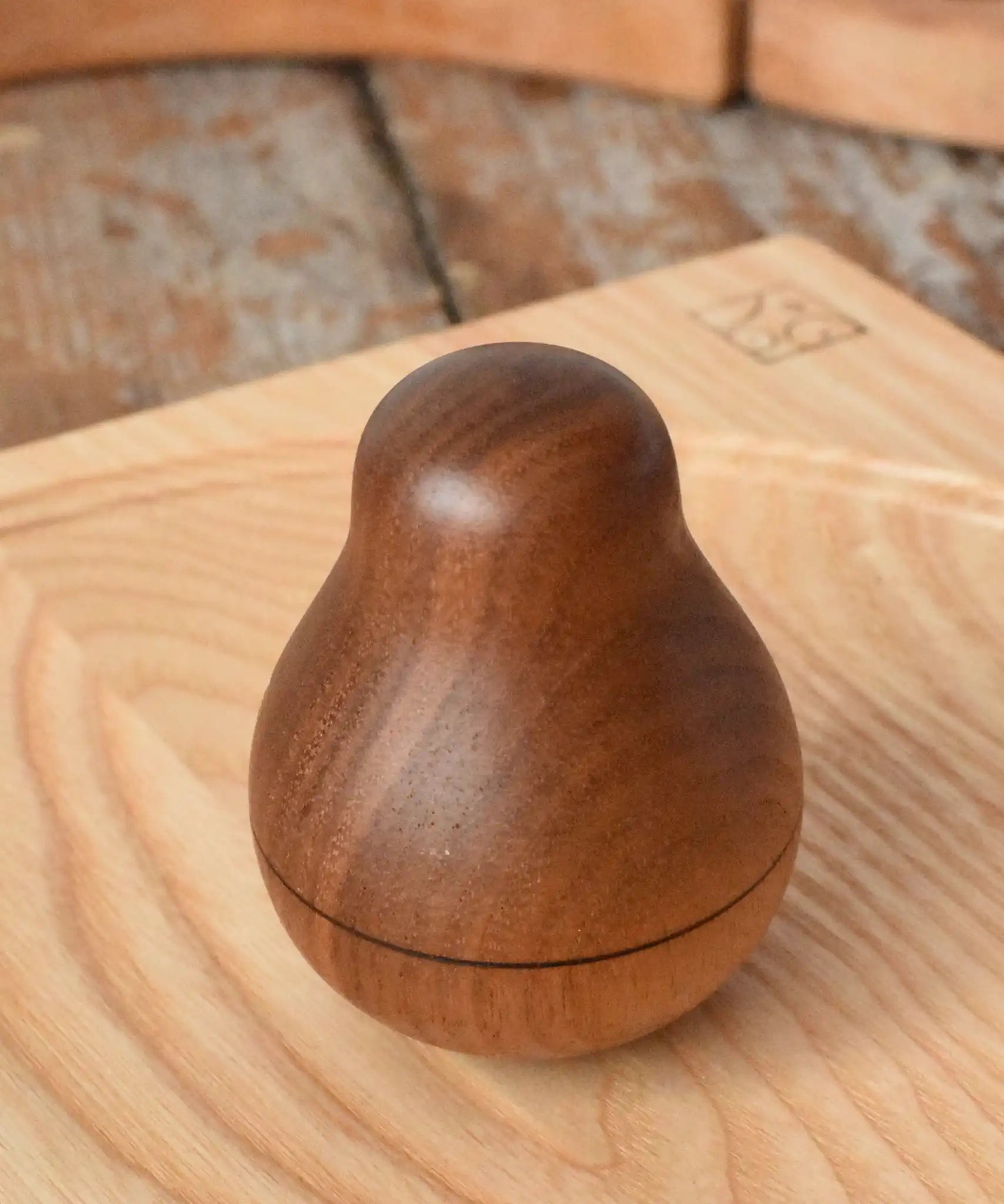 Mader Kreiselmanufaktur walnut roly-poly pear wooden toy placed on an ash spinning plate in the Babipur playroom. 