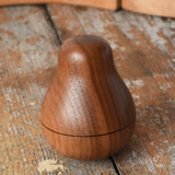 Mader Kreiselmanufaktur walnut roly-poly pear wooden toy placed on a wooden surface in the Babipur playroom. 