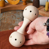 Mader Kreiselmanufaktur traditional wooden baby rattle in an adult's hand in the Babipur playroom. 