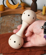 Mader Kreiselmanufaktur traditional wooden baby rattle in an adult's hand in the Babipur playroom. 