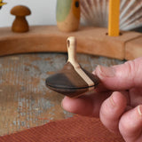 Mader Charlie finger spinning top shown resting on an adult's hand.