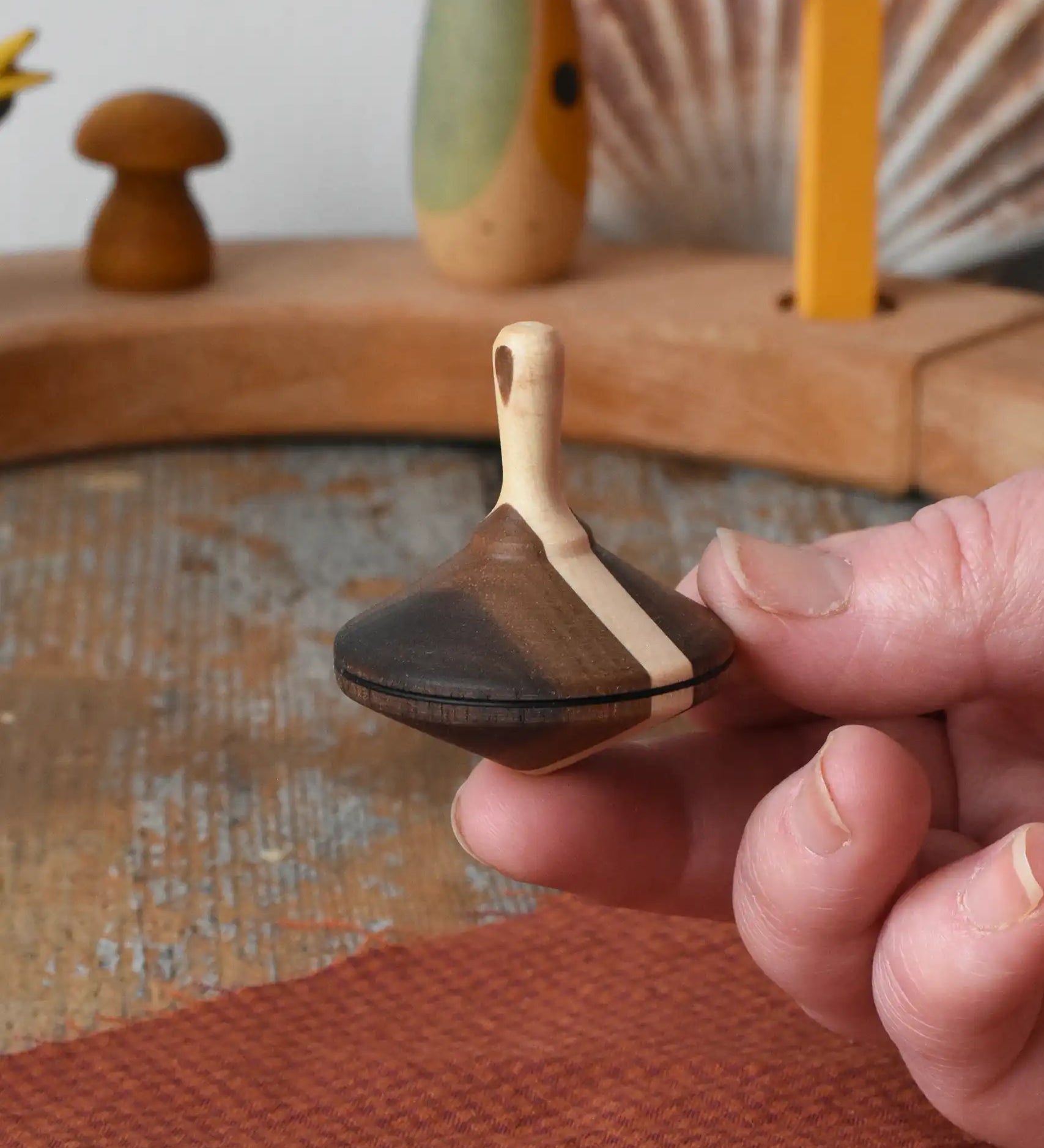 Mader Charlie finger spinning top shown resting on an adult's hand.