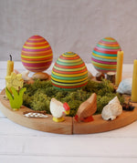 Mader wooden roly-poly wooden eggs placed in a seasonal display with a Grimm's celebration ring. 