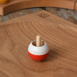 Mader Kreiselmanufaktur fly agaric mushroom turn over spinning top placed on an oak spinning plate in the Babipur playroom.