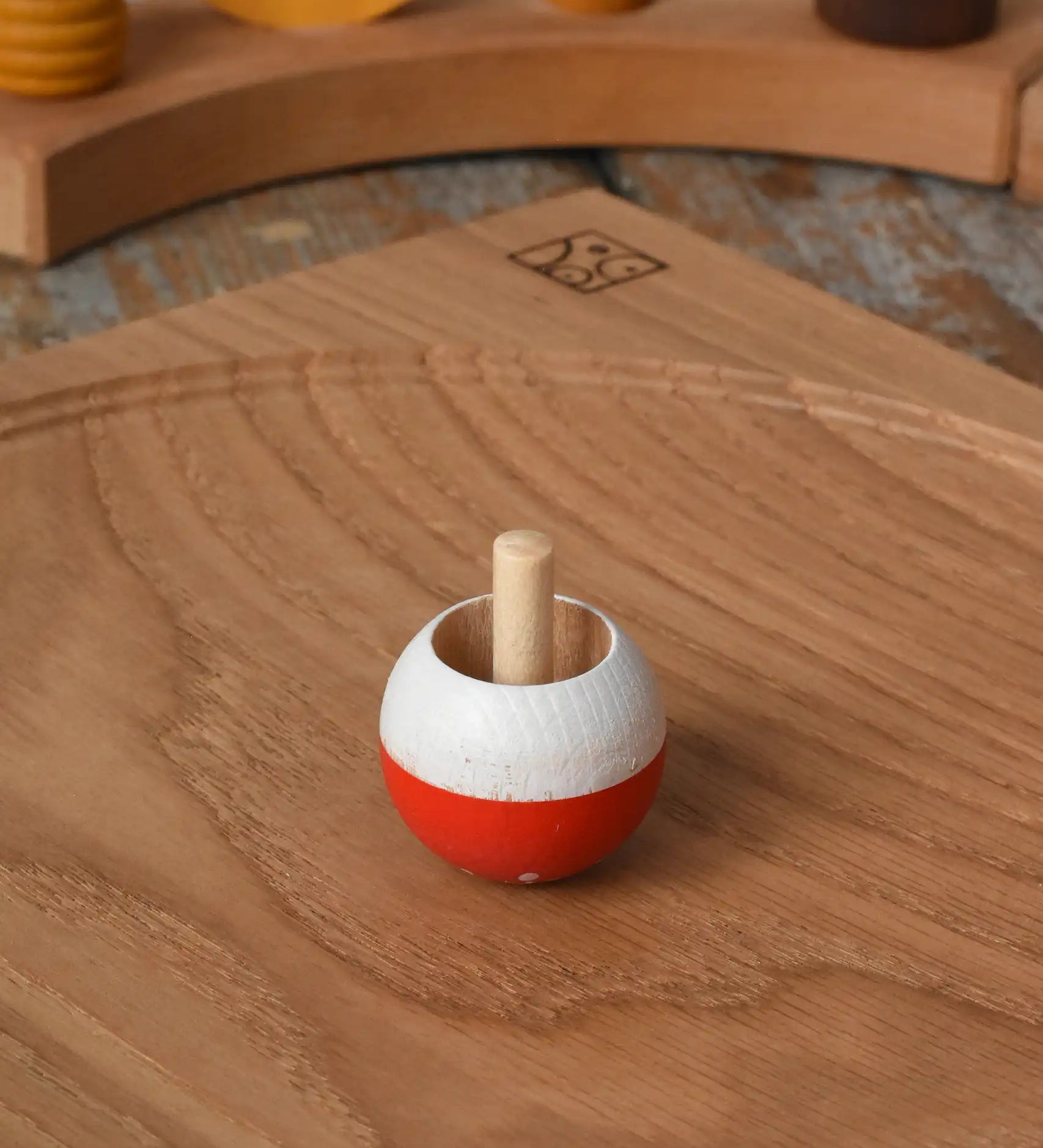 Mader Kreiselmanufaktur fly agaric mushroom turn over spinning top placed on an oak spinning plate in the Babipur playroom.
