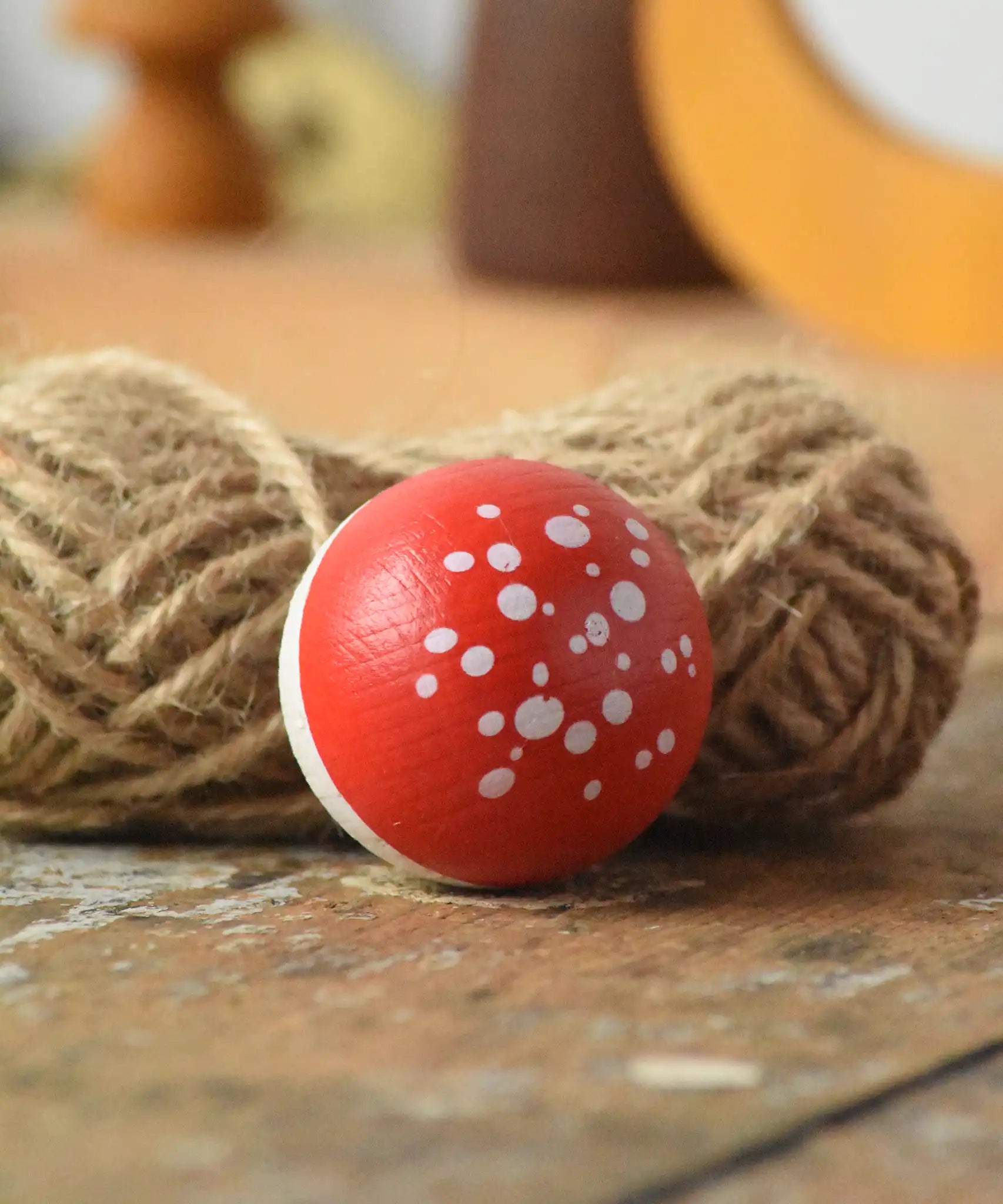 Close up of the top of the Mader Kreiselmanufaktur fly agaric mushroom turn over spinning top placed on a wooden surface n the Babipur playroom.