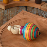 Mader Kreiselmanufaktur ring pull string spinning top placed on a cherry wood spinning plate in the Babipur playroom.
