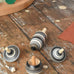 Mader Kreiselmanufaktur graphite spinning top learning set placed on a wooden surface in the Babipur playroom. The set has 5 striped tops in shades of grey, white and black.