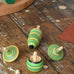 Mader Kreiselmanufaktur green grass spinning top learning set placed on a wooden surface in the Babipur playroom. 