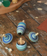 Mader Kreiselmanufaktur ice blue spinning top learning set on a wooden surface in the Babipur playroom. 