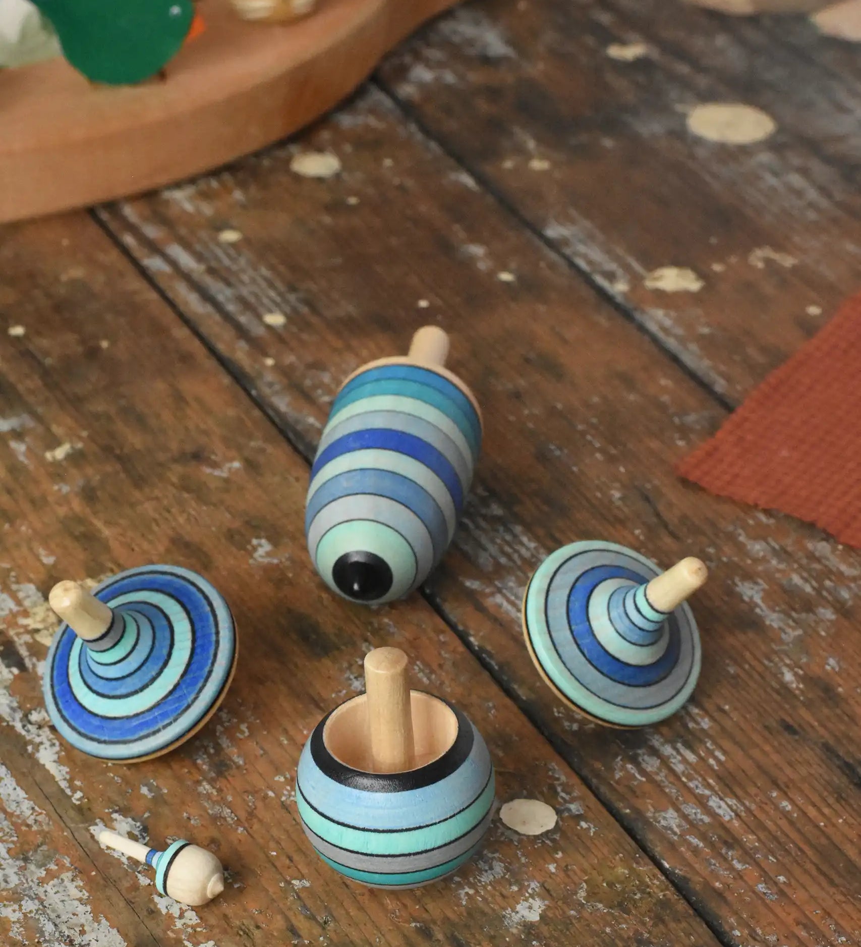 Mader Kreiselmanufaktur ice blue spinning top learning set on a wooden surface in the Babipur playroom. 