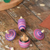 Mader lilac purple spinning top learning set placed on a wooden surface in the Babipur playroom. 