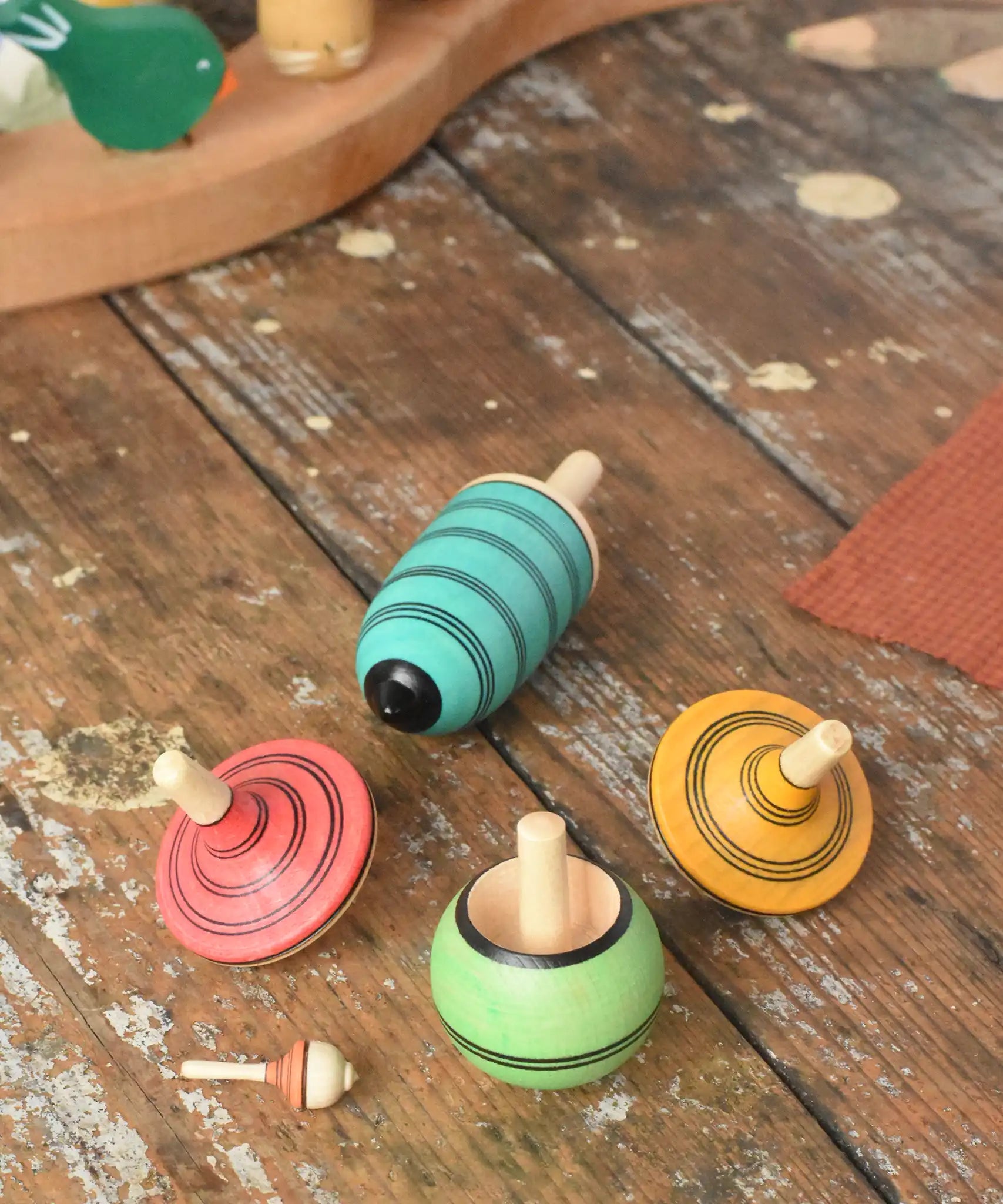Mader Kreiselmanufaktur multicolour spinning top learning set placed on a wooden surface in the Babipur playroom. 