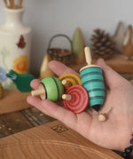 The Mader Kreiselmanufaktur multicolour spinning top learning set placed in an adult's hand in the Babipur playroom. 