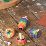 Mader Kreiselmanufaktur rainbow spinning top learning set placed on a wooden surface in the Babipur playroom. 