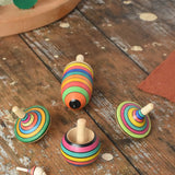 Mader Kreiselmanufaktur striped spinning top learning set placed on a wooden surface in the Babipur playroom. 