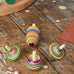 Mader Kreiselmanufaktur striped spinning top learning set placed on a wooden surface in the Babipur playroom. 