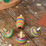 Mader Kreiselmanufaktur striped spinning top learning set placed on a wooden surface in the Babipur playroom. 