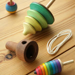 Mader kids wooden pull string tree spinning top toy on a wooden background