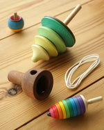 Mader kids wooden pull string tree spinning top toy on a wooden background