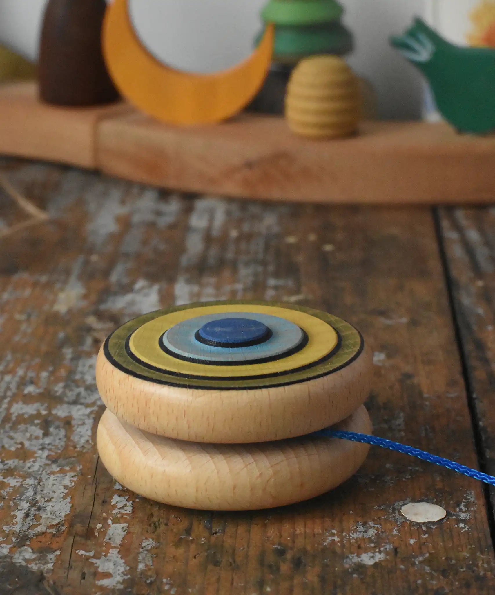 Mader Kreiselmanufaktur yoyo harlequin placed on it's side on a wooden desk in the Babipur playroom.