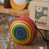 Mader yoyo rainbow placed on a wooden desk in the Babipur playroom. Cardboard packaging box can be seen in the background.