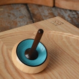 Mader Zwirbel Spinning Top in blue placed on an an ash spinning board  in the Babipur playroom.