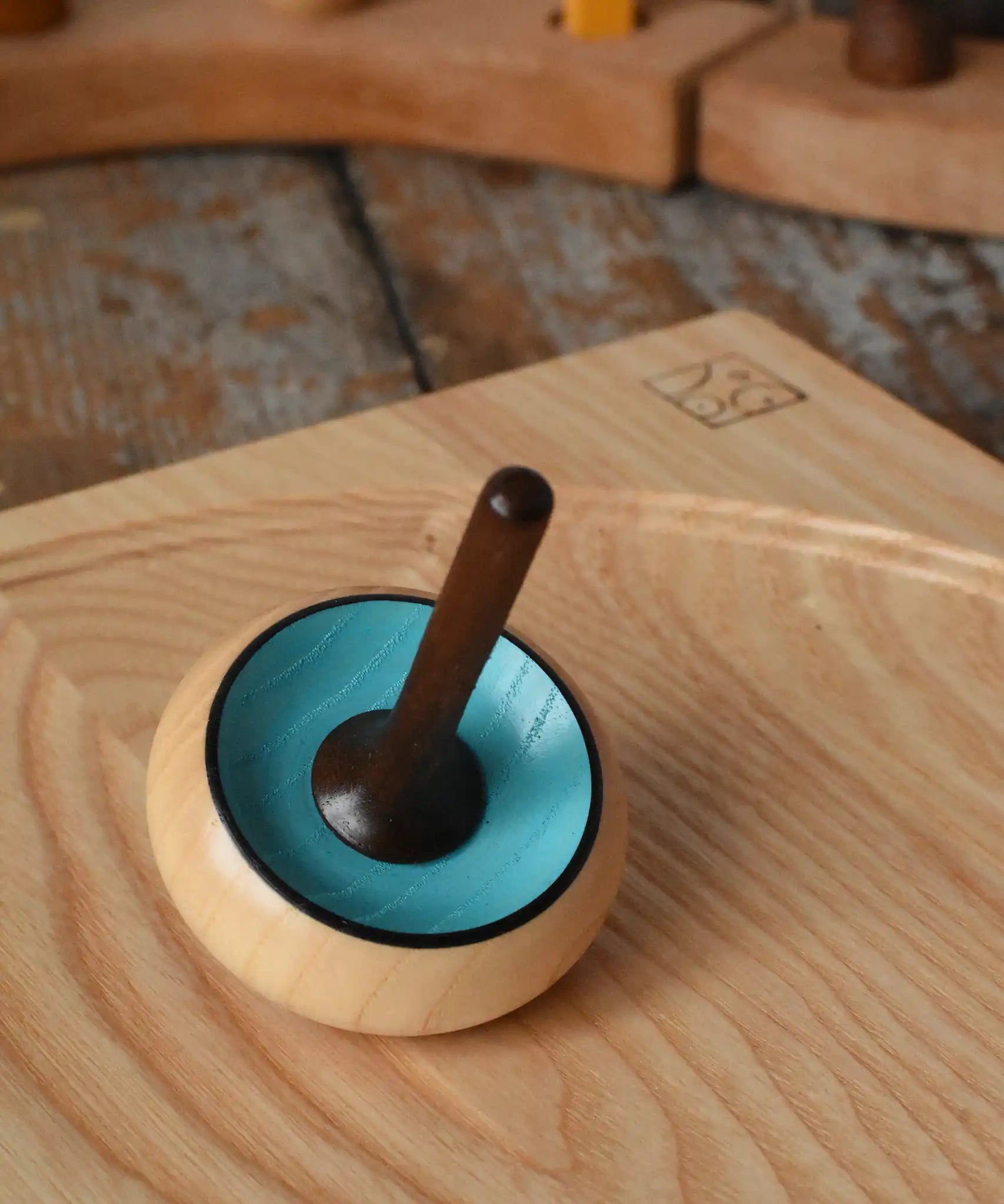 Mader Zwirbel Spinning Top in blue placed on an an ash spinning board  in the Babipur playroom.