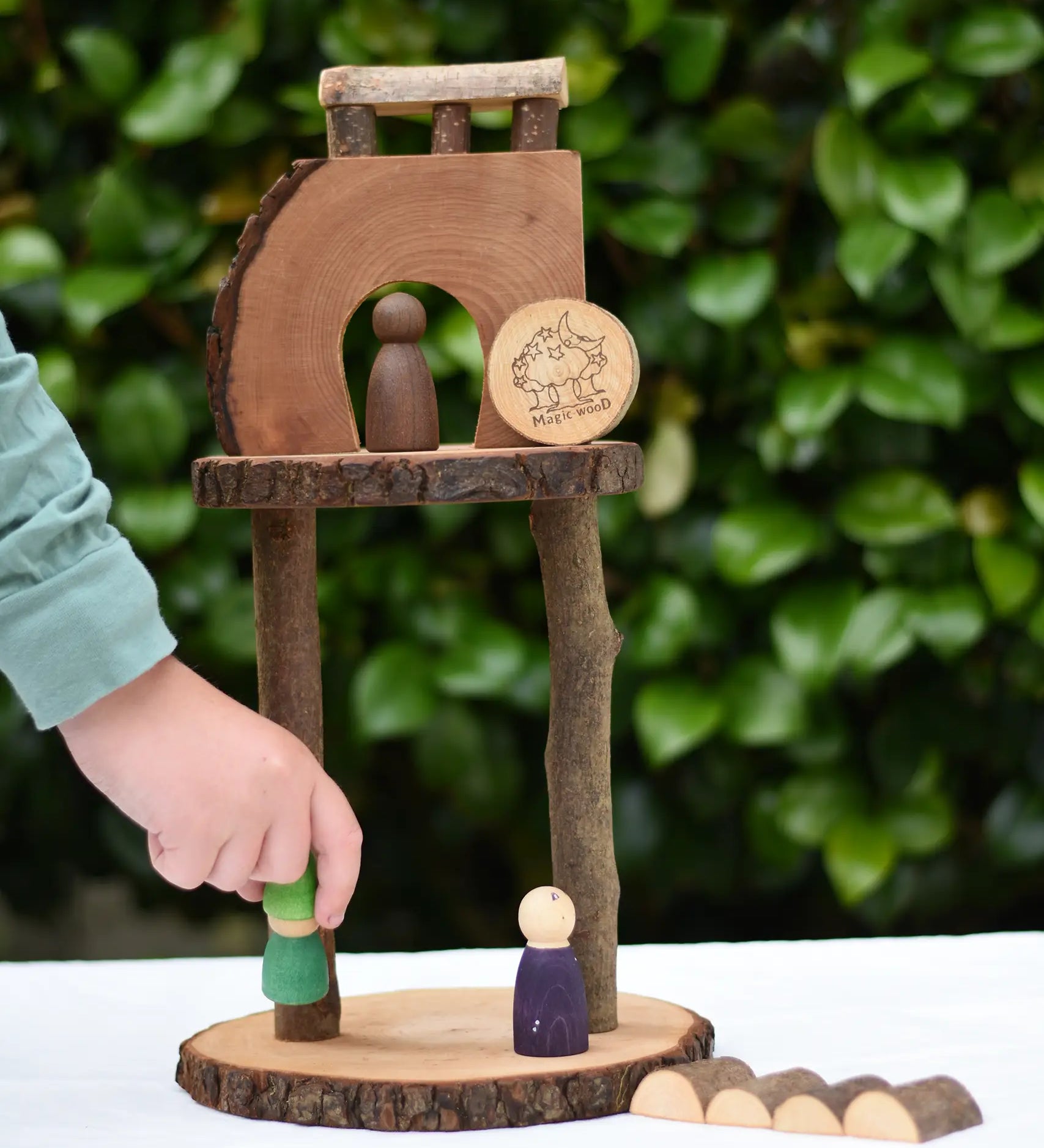 Child placing a Nin on s structure created using pieces from the Magic Wood Eco Blocks Big Box 70 piece set .