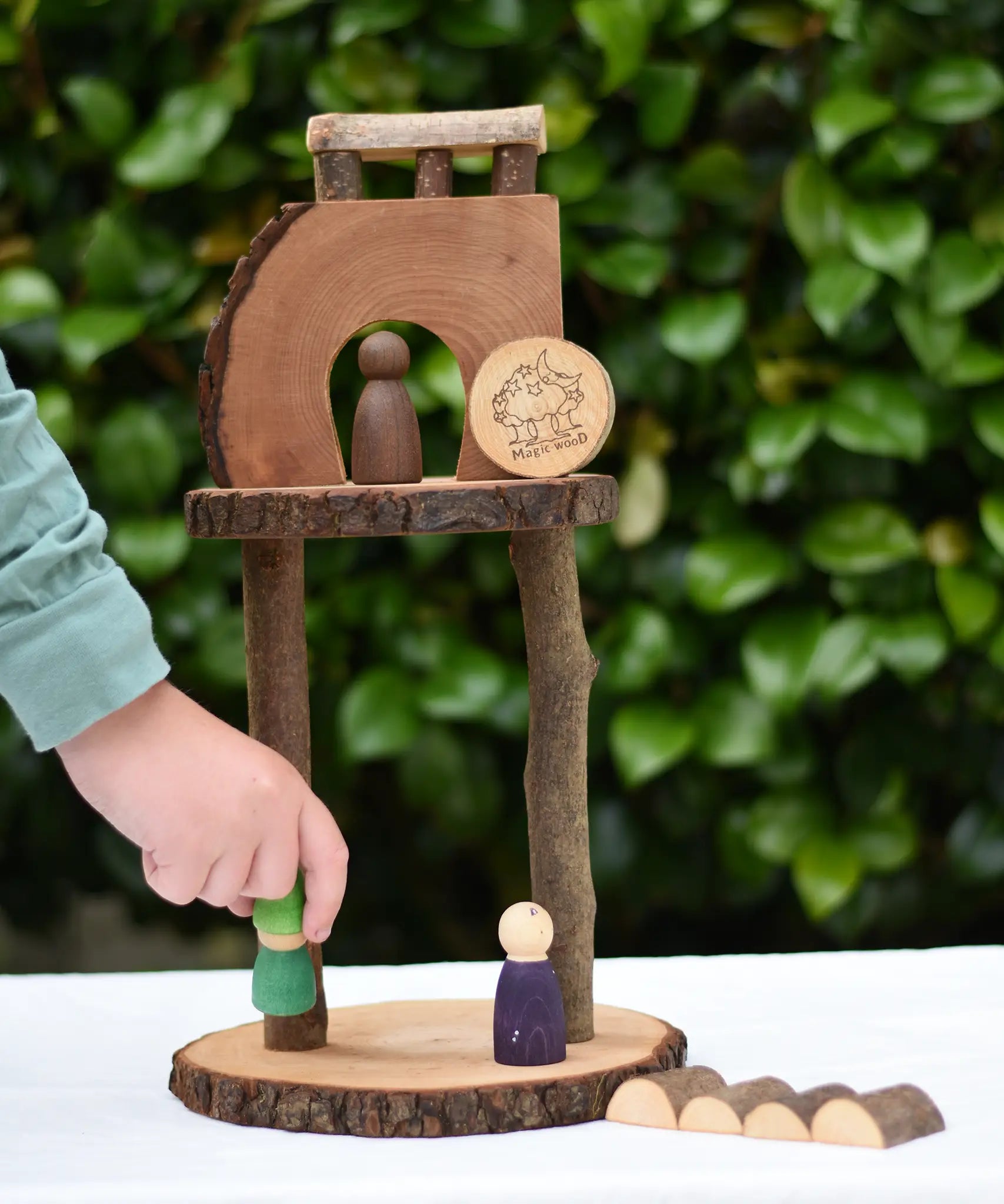 Child placing a Nin on s structure created using pieces from the Magic Wood Eco Blocks Big Box 70 piece set .
