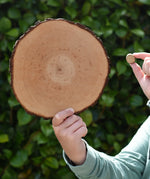 Child holding the largest and smallest piece from the Magic Wood Eco Blocks Big Box 70 piece set.