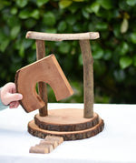 Child placing the door cutout log piece from the Magic Wood Eco Blocks Big Box 70 piece set in a stack. 