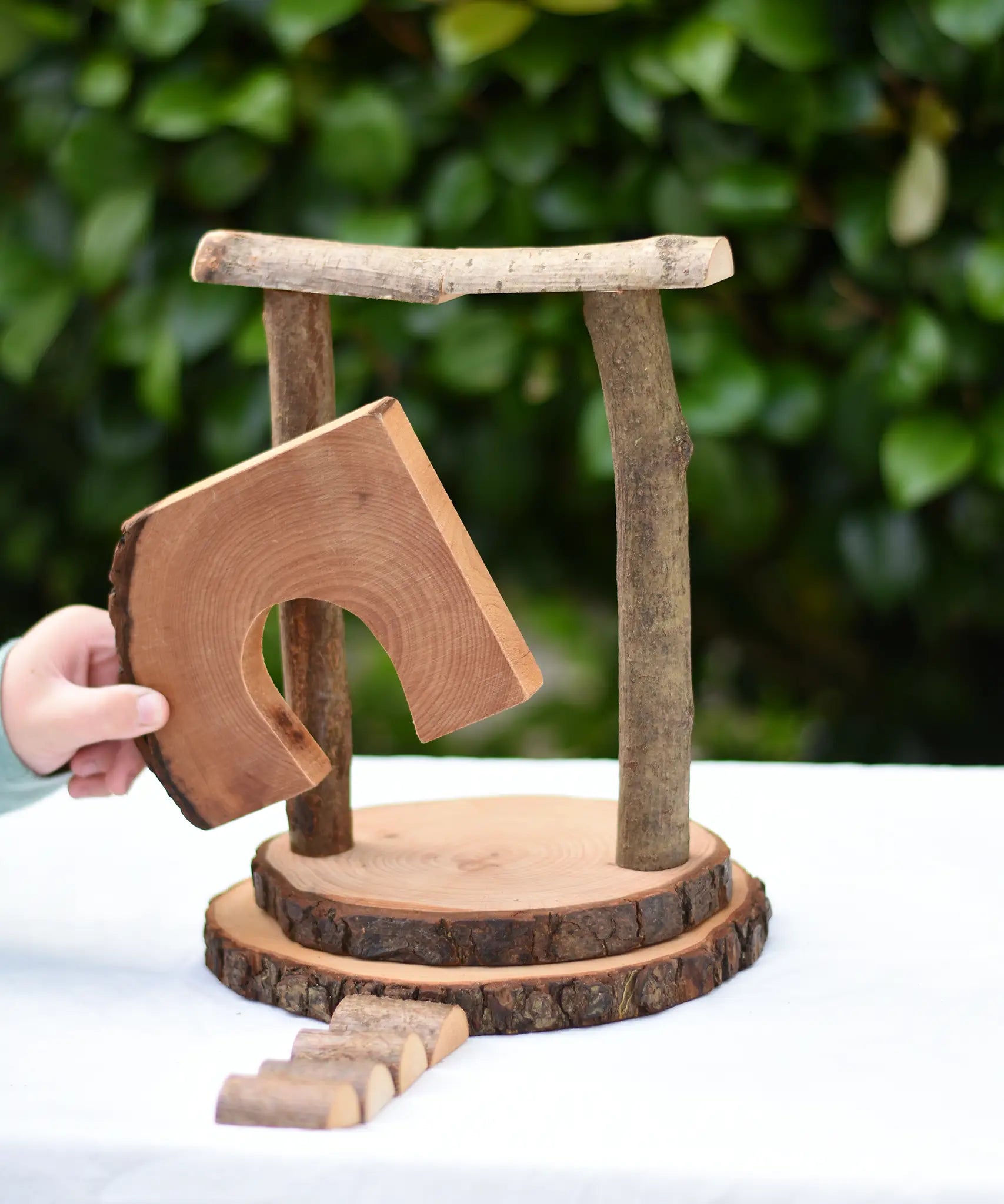 Child placing the door cutout log piece from the Magic Wood Eco Blocks Big Box 70 piece set in a stack. 