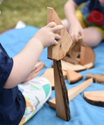 Child stacking pieces from the Magic Wood Eco Blocks Big Box 70 piece set.