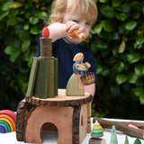 Child playing with a house built using pieces from the Magic Wood Eco Blocks Big Box 70 piece set. 