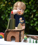 Child playing with a house built using pieces from the Magic Wood Eco Blocks Big Box 70 piece set. 