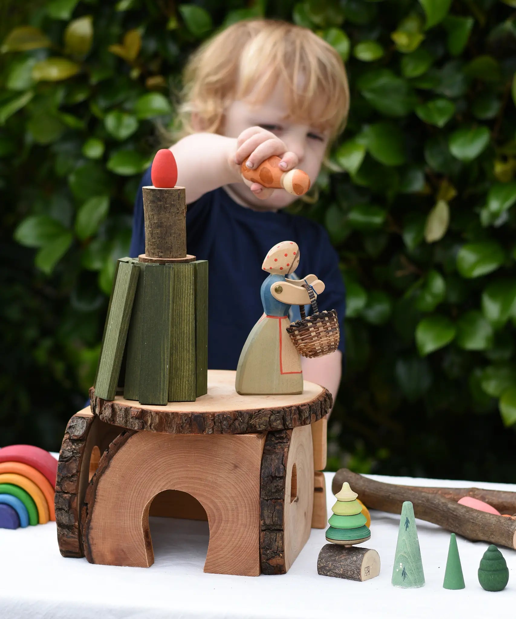 Child playing with a house built using pieces from the Magic Wood Eco Blocks Big Box 70 piece set. 