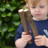 Child holding two long log pieces from the Magic Wood Eco Blocks Big Box 70 piece set.